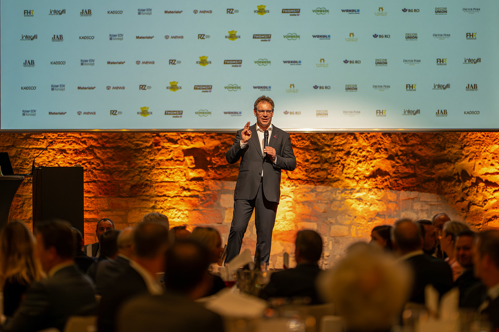 Corporate speaker presenting to guests at a formal business event in Germany