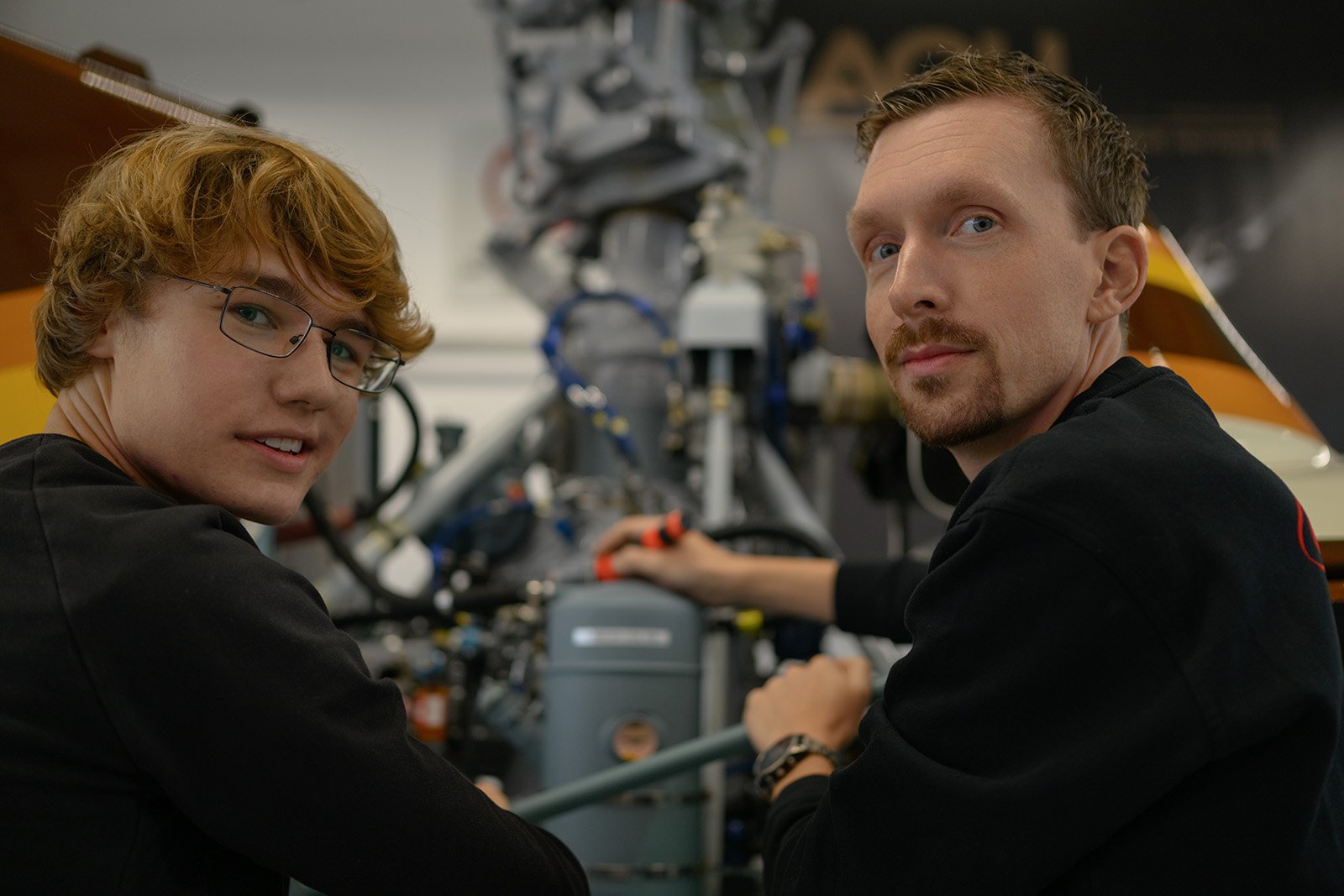 Two technical employees working at industrial machinery in a German production facility