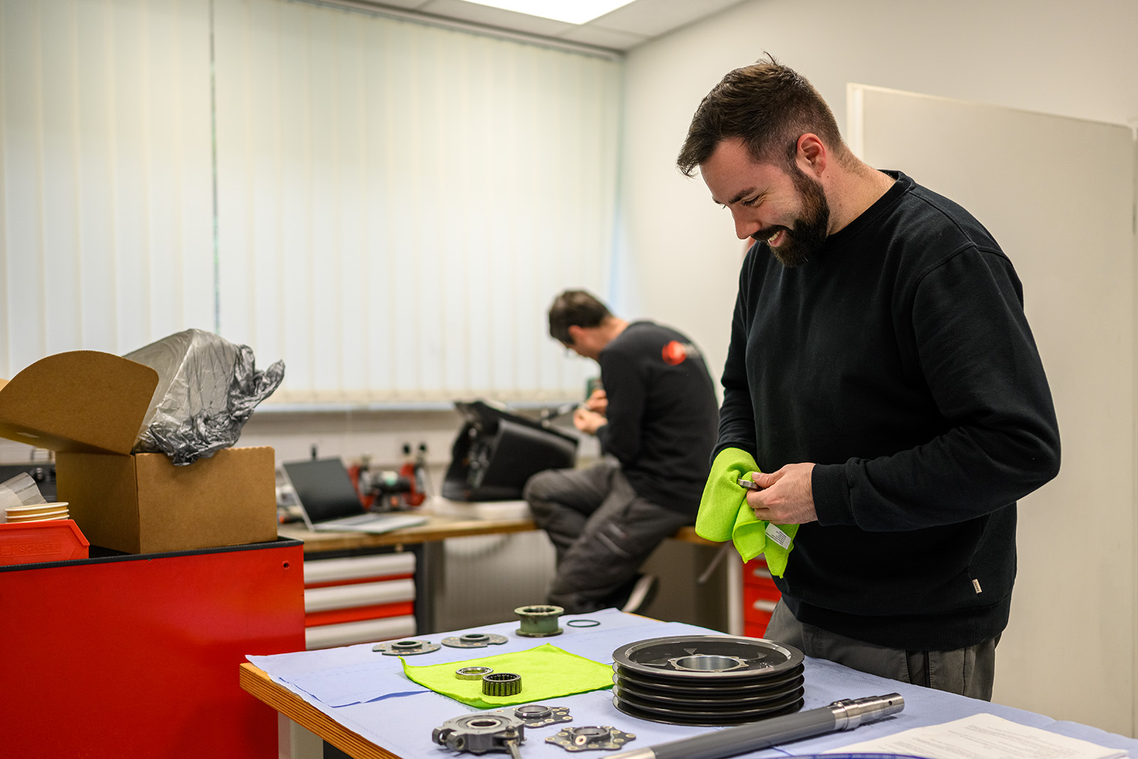 Technician working with mechanical components in an industrial workshop